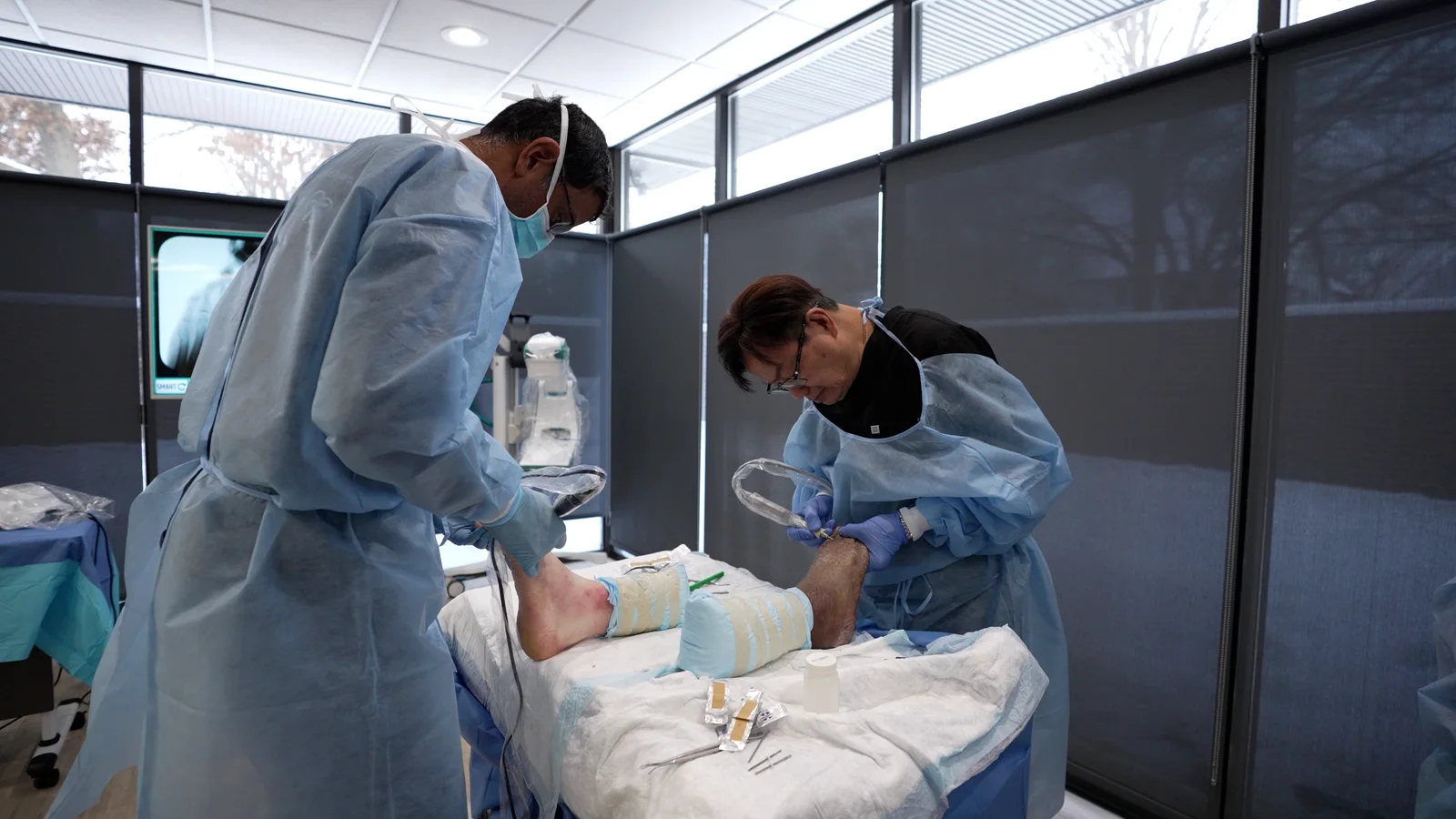 Two surgeons working at their individual cadaver stations
